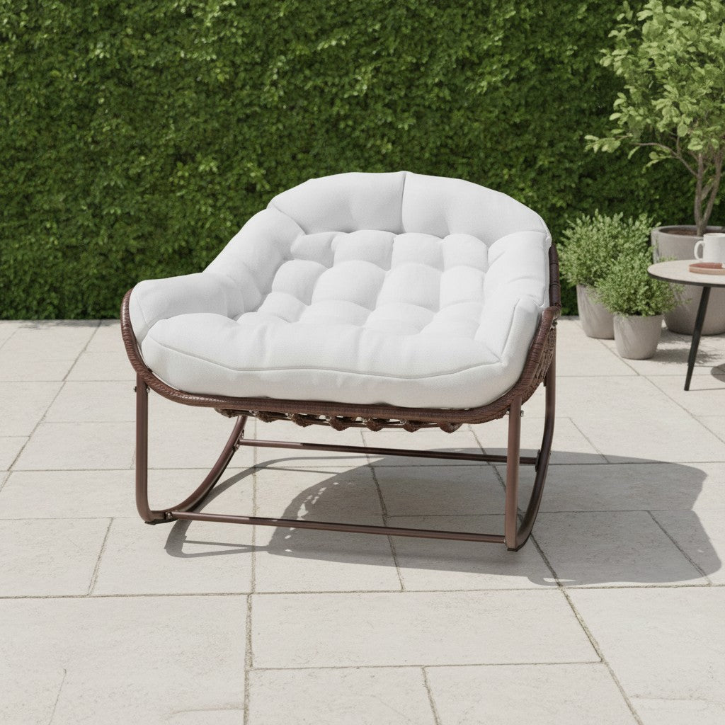 Fauteuil à Bascule Rotin Synthétique Forme Œuf blanc cassé sur un patio de jardin